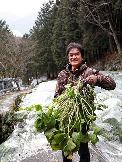 大きく育ったわさびを手にする、「わさびの門前」の白鳥義彦さん